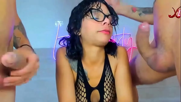 Girl With Glasses And A Teasing Look Takes Two Massive Cocks Deep Down Her Throat